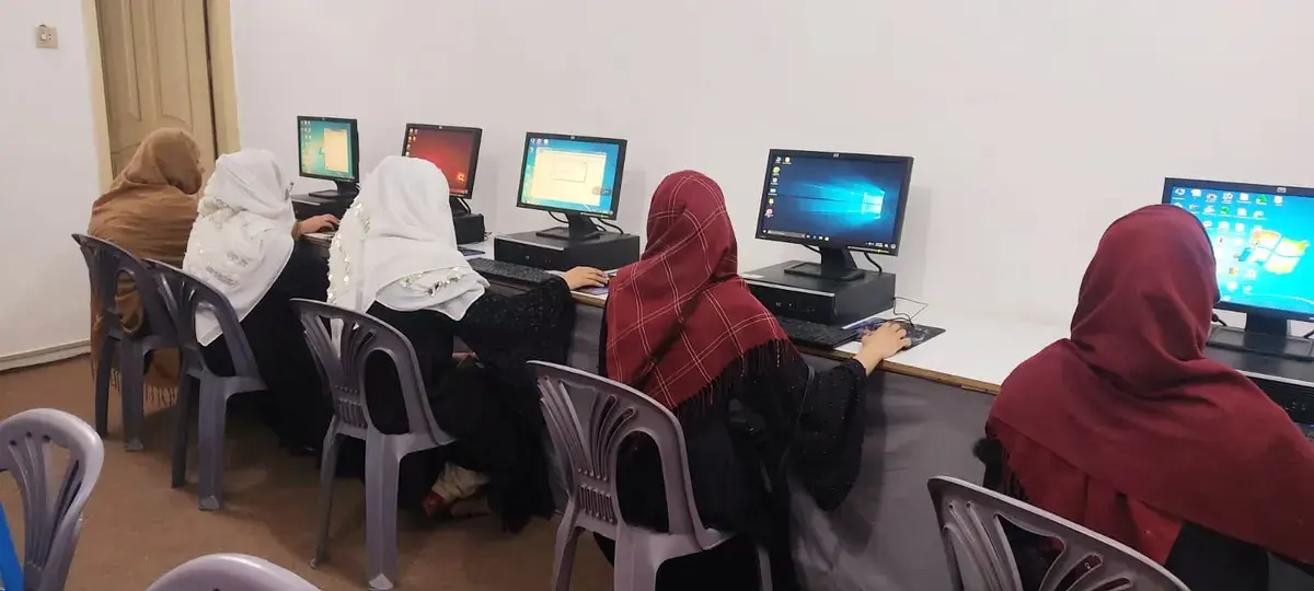 Female students using computers during an academy training session